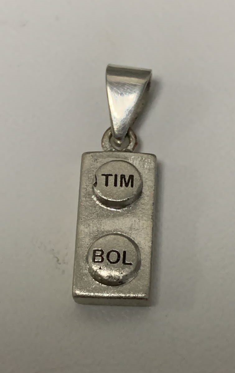 Unique pendant crafted from a LEGO piece, finished with a polished metal setting for wearable design