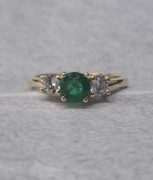 Gold ring with the green center gemstone re-set